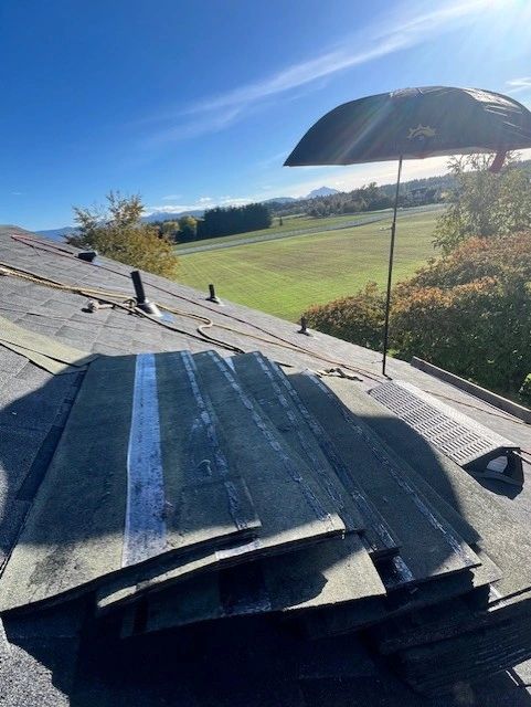 SunSafe Shield shade set up next to shingle bundles on a roof